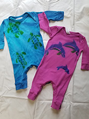 pink onsie with dolphins, blue onesie with turtles